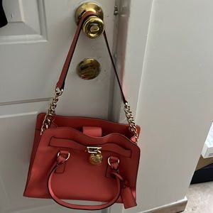 This is a brand new Michael Kors bag. It’s flamingo pink and size: 12.5 x 4 x 9